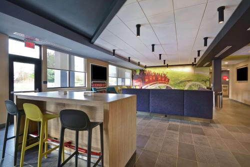 a cafeteria with a large wooden table and chairs at Tru By Hilton Mason King's Island in Mason