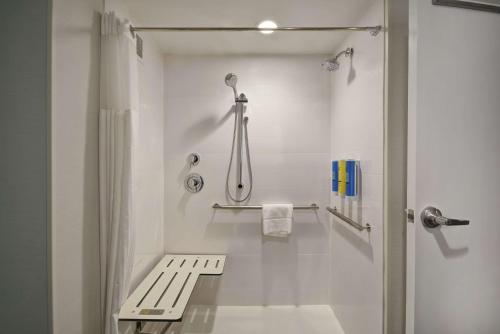 a bathroom with a shower and a bench in it at Tru By Hilton Mason King's Island in Mason