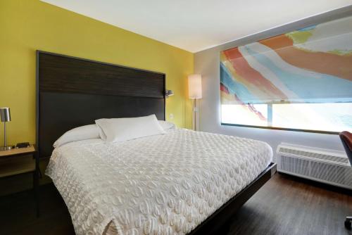a bedroom with a white bed and a painting on the wall at Tru By Hilton Mason King's Island in Mason
