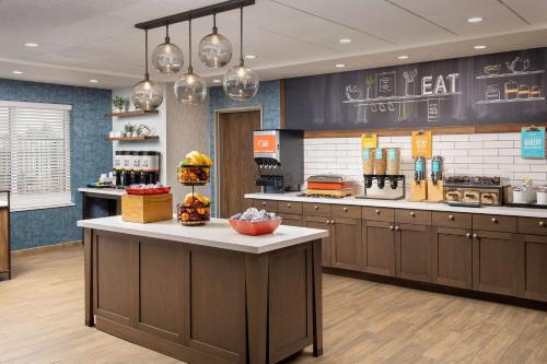 a kitchen with brown cabinets and a counter at Hampton Inn & Suites Rapid City Rushmore, SD in Rapid City