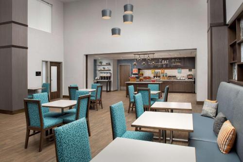 a restaurant with tables and chairs and a kitchen at Hampton Inn & Suites Rapid City Rushmore, SD in Rapid City