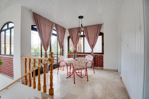 a dining room with a table and chairs and windows at Apartman Platan in Metković