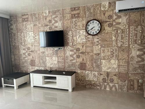a wall with a clock and a tv on it at superior villas in Tbilisi City