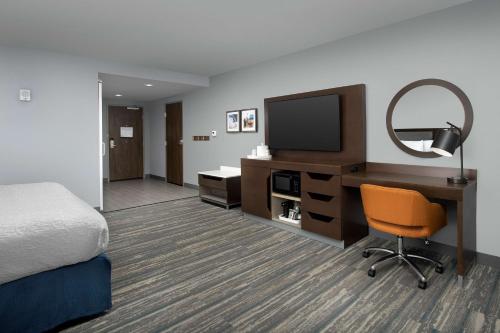 a hotel room with a bed and a desk with a television at Hampton Inn & Suites Rapid City Rushmore, SD in Rapid City