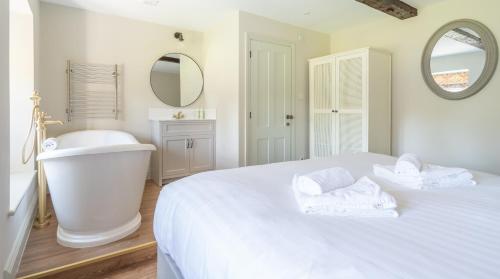a bathroom with a bed and a tub and a sink at Cunsey Mill House in Far Sawrey