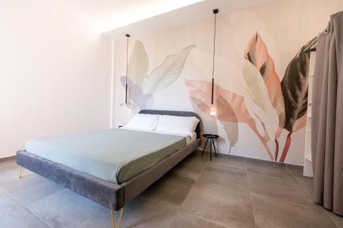 una camera con letto e un murale di foglie di Casa Arbanella a Varazze
