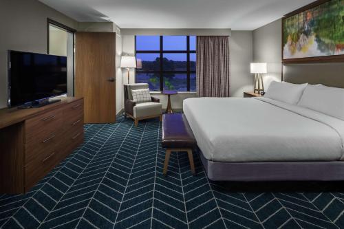 a hotel room with a large bed and a television at The Bevy Hotel Boerne, A Doubletree By Hilton in Boerne