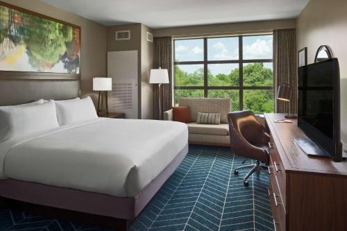 una camera d'albergo con letto, scrivania e TV di The Bevy Hotel Boerne, A Doubletree By Hilton a Boerne
