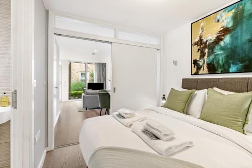 Tailored Stays - Central Cambridge, River Walk Apartments في كامبريدج: غرفة نوم بيضاء مع سرير أبيض كبير مع وسائد خضراء