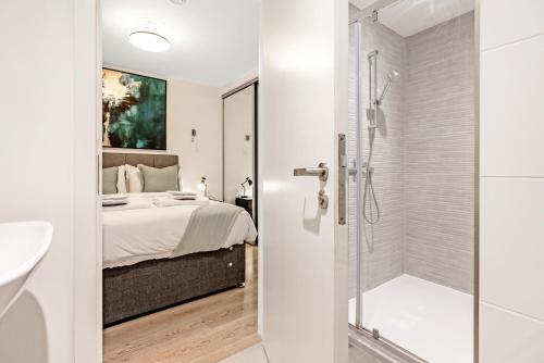 a bathroom with a shower and a bedroom with a bed at Tailored Stays - Central Cambridge, River Walk Apartments in Cambridge