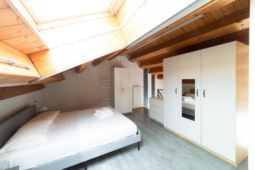 a bedroom with a white bed and wooden ceilings at Hbhall Residenze Darsena in Milan