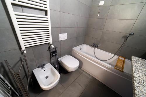 a bathroom with a toilet and a tub and a sink at Hbhall Residenze Darsena in Milan