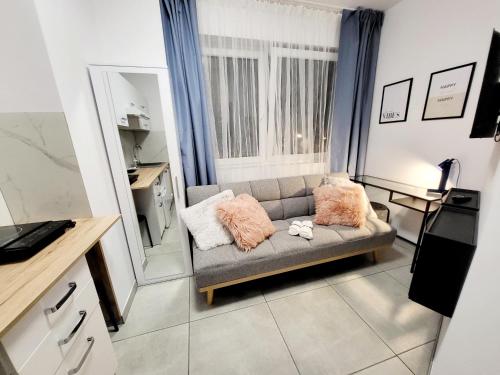 a living room with a couch and a mirror at Mini Apartamenty Poznań in Poznań