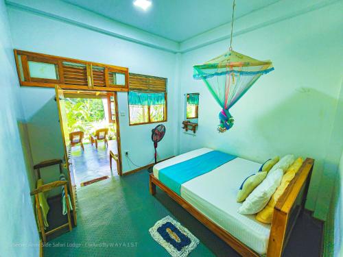- une chambre avec un lit dans une pièce dotée d'une fenêtre dans l'établissement Secret River Side Safari Lodge, à Uda Walawe