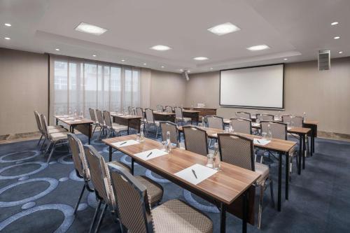 a conference room with tables and chairs and a projection screen at DoubleTree by Hilton Istanbul Gayrettepe in Istanbul
