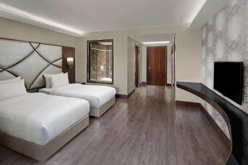 a hotel room with two beds and a tv at DoubleTree by Hilton Istanbul Gayrettepe in Istanbul