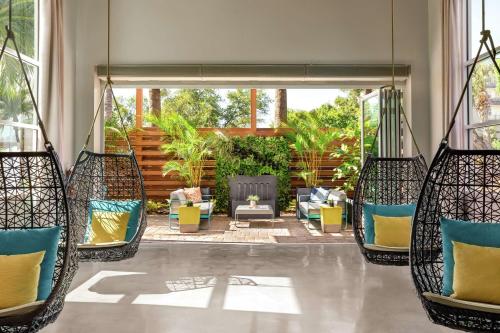 a porch with three chairs and a swing at Hotel Alba Tampa, Tapestry Collection By Hilton in Tampa