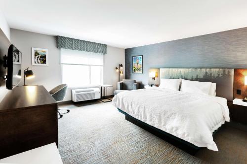 a hotel room with a large bed and a living room at Hampton Inn & Suites by Hilton Québec - Beauport in Quebec City