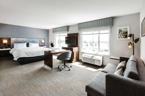 a hotel room with a bed and a desk at Hampton Inn & Suites by Hilton Québec - Beauport in Quebec City