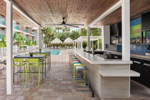 an outdoor bar with chairs and tables and a pool at Hotel Alba Tampa, Tapestry Collection By Hilton in Tampa