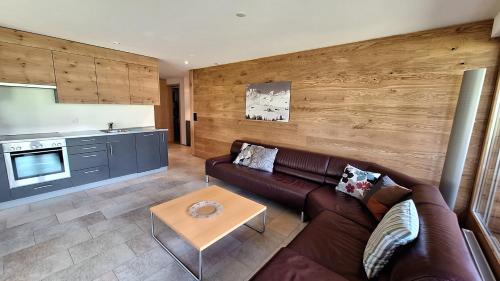 a living room with a brown couch and a table at Haus Bella Vista in Riederalp