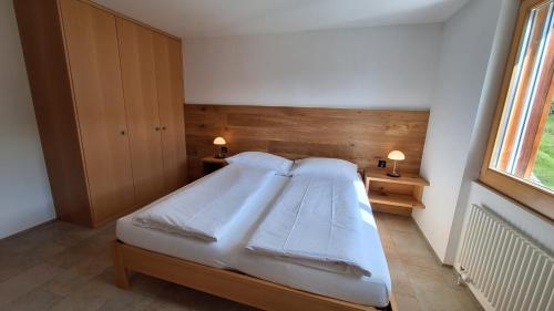 a bedroom with a bed with two pillows and a window at Haus Bella Vista in Riederalp