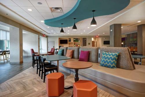 a waiting room with tables and chairs and a couch at Home2 Suites By Hilton Atlanta Marietta, Ga in Marietta