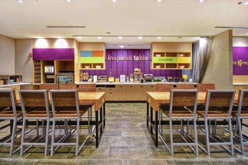 マリエッタにあるHome2 Suites By Hilton Atlanta Marietta, Gaの木製テーブルと椅子付きの広いキッチン