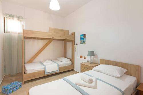 a bedroom with two bunk beds with white sheets at New Apt Close to Medical Center with Garden in Heraklio Town