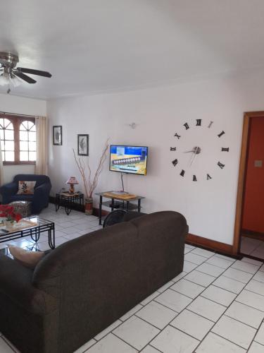 a living room with a couch and a clock on the wall at Melrose Place in Montego Bay