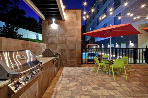 a patio with a table with chairs and an umbrella at Home2 Suites By Hilton Birmingham/Fultondale, Al in Fultondale