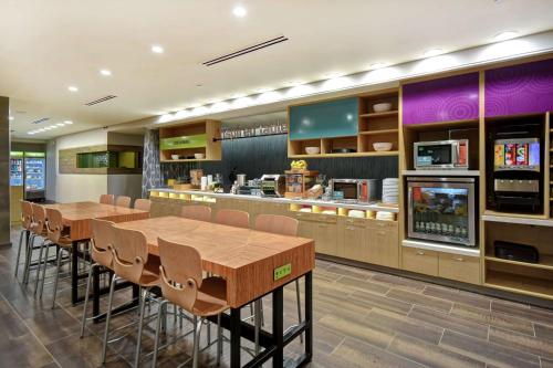 a restaurant with wooden tables and chairs and a counter at Home2 Suites By Hilton Birmingham/Fultondale, Al in Fultondale