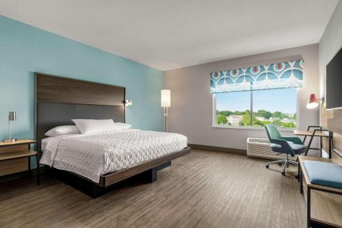 a bedroom with a bed and a desk and a window at Tru By Hilton Hershey Chocolate Avenue in Hershey