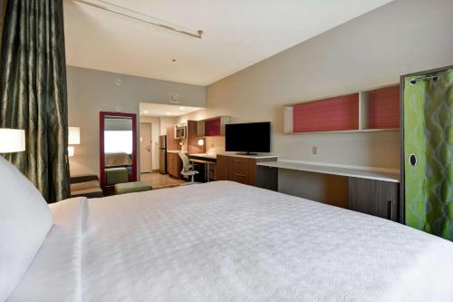 a large bedroom with a white bed and a kitchen at Home2 Suites By Hilton Birmingham/Fultondale, Al in Fultondale