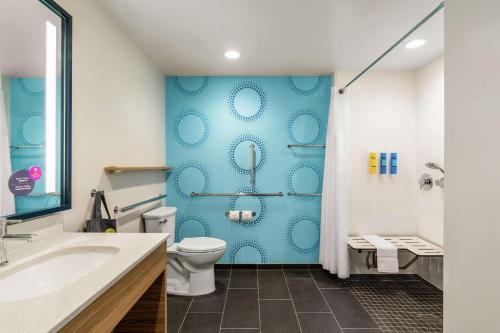 a bathroom with a toilet and a blue wall at Tru By Hilton Hershey Chocolate Avenue in Hershey