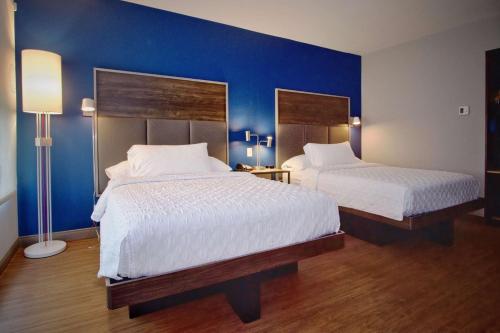 Tru By Hilton Oklahoma City Nw Expressway في مدينة اوكلاهوما: سريرين في غرفة بجدران زرقاء
