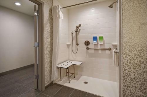 a bathroom with a shower with a bench in it at Home2 Suites By Hilton Birmingham/Fultondale, Al in Fultondale