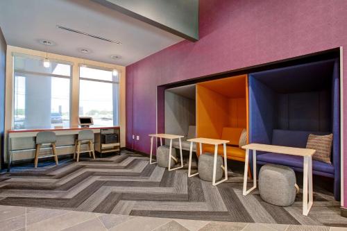 a room with purple walls and tables and chairs at Tru By Hilton Grand Prairie in Grand Prairie