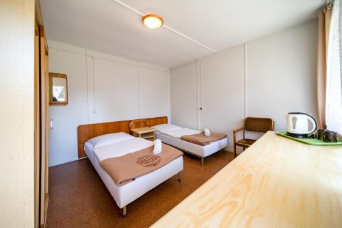 a hospital room with two beds and a chair at OW Gromada Pod Topolami in Międzyzdroje