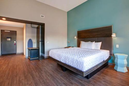 a bedroom with a large bed with a wooden headboard at Tru By Hilton Grand Prairie in Grand Prairie