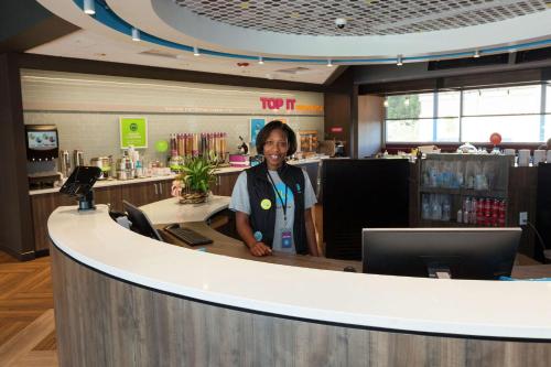 a woman is standing behind a counter in a store at Tru By Hilton Georgetown in Georgetown