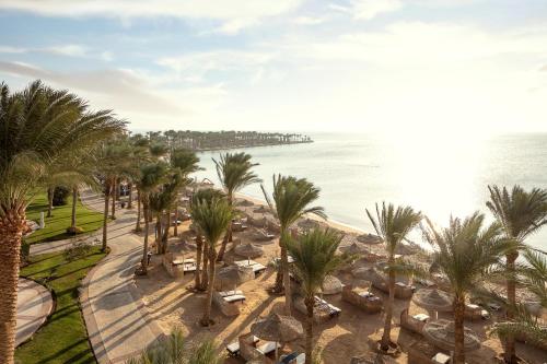Palm Royale Resort - Soma Bay في الغردقة: اطلالة على شاطئ به نخل والمحيط
