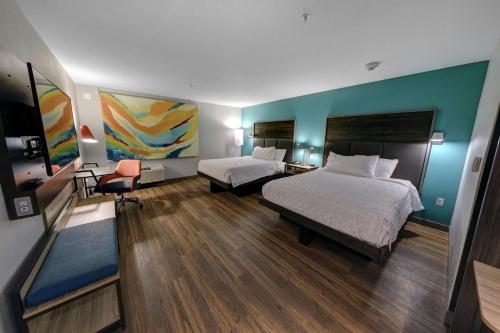 ジョージタウンにあるTru By Hilton Georgetownのベッド2台が備わる客室で、壁には絵画が飾られています。