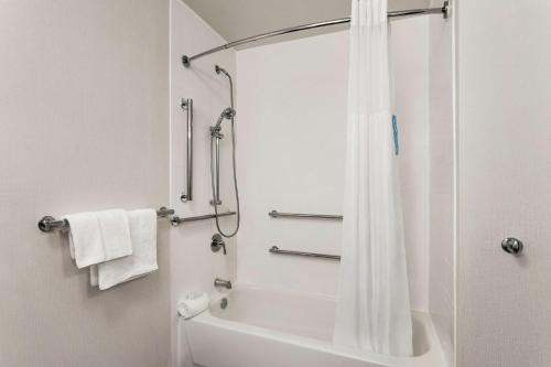 a bathroom with a shower with a tub and a toilet at Hampton Inn Houston Hobby Airport in Houston