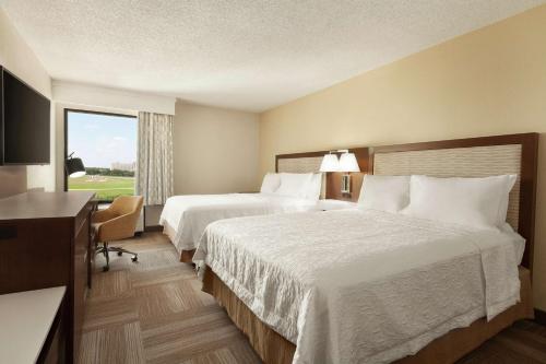 a hotel room with two beds and a window at Hampton Inn Houston Hobby Airport in Houston