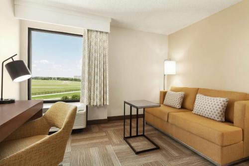 a living room with a couch and a table and a window at Hampton Inn Houston Hobby Airport in Houston