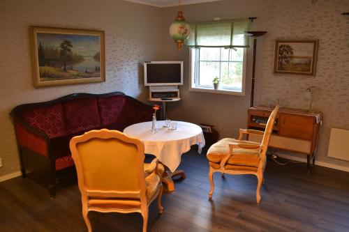 - un salon avec un canapé, une table et des chaises dans l'établissement Föllingen Hotell, à Kisa