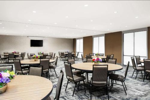 a conference room with tables and chairs and a tv at Home2 Suites by Hilton Long Island Brookhaven in Yaphank