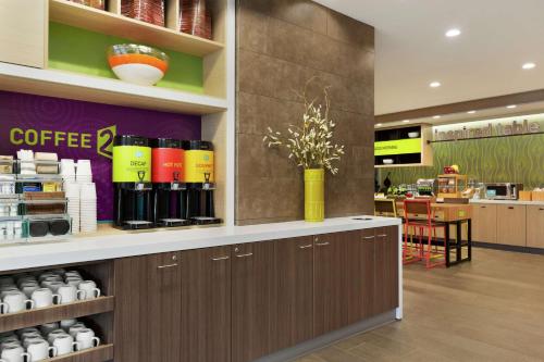 uma cafeteria com balcão e um especialista em café em Home2 Suites By Hilton Portland Airport em Portland