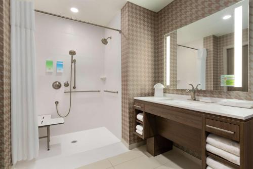 a bathroom with a shower and a sink and a tub at Home2 Suites By Hilton Portland Airport in Portland